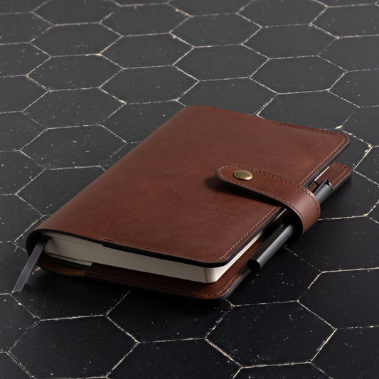 full grain leather planner cover for full focus planner by Michael Hyatt pictured in vintage brown leather on dark background