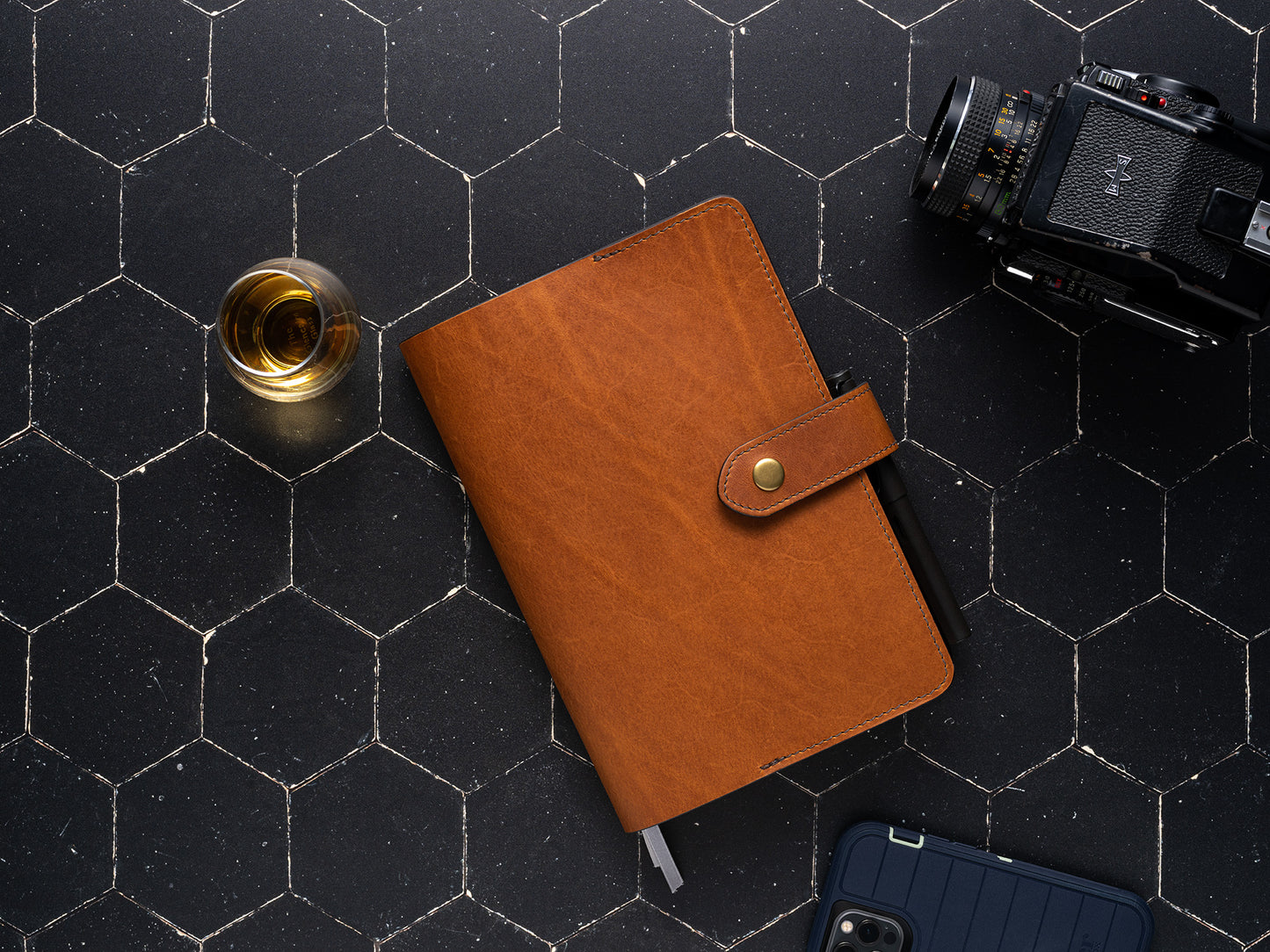 front closed leather planner cover to fit full focus planner by Michael Hyatt on dark background with camera 