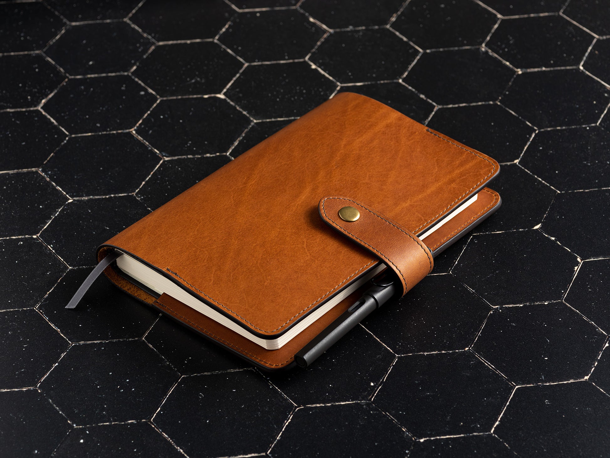 full grain leather planner cover to fit full focus planner by Michael Hyatt in saddle tan front with pen holder on dark background